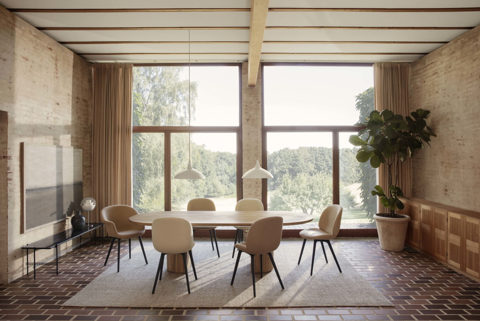 Esszimmer mit ovalem Tisch, Stühlen und zwei weißen 1965 Pendelleuchten von Gubi.