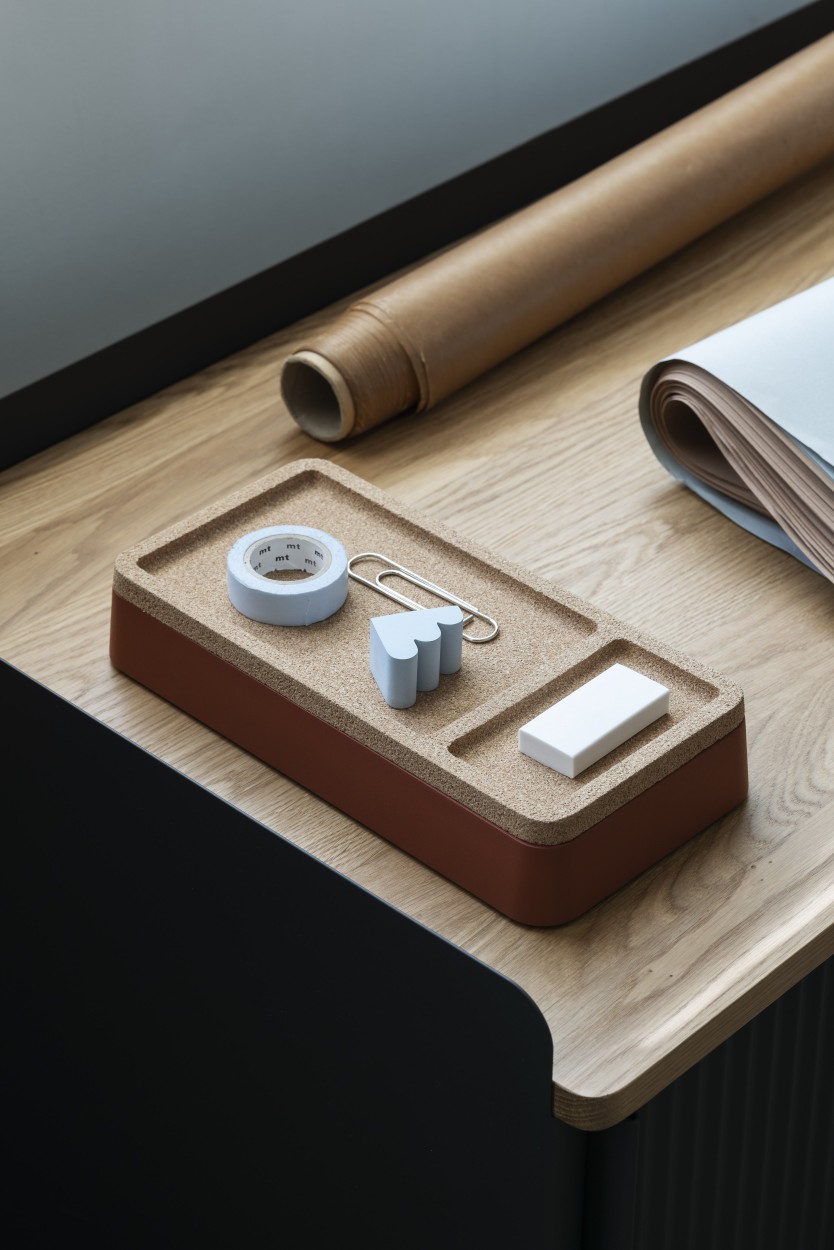 Muuto Arrange Desktop Serie Konfiguration 1: Schreibtisch-Organizer aus Kork mit Büroartikeln auf einem Holztisch.