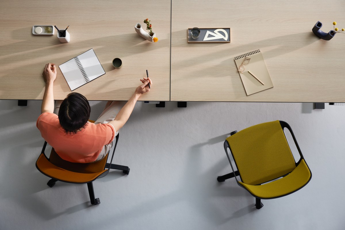 Draufsicht: Person am Schreibtisch auf Numo Task Bürodrehstuhl mit Rollen von Aeris.