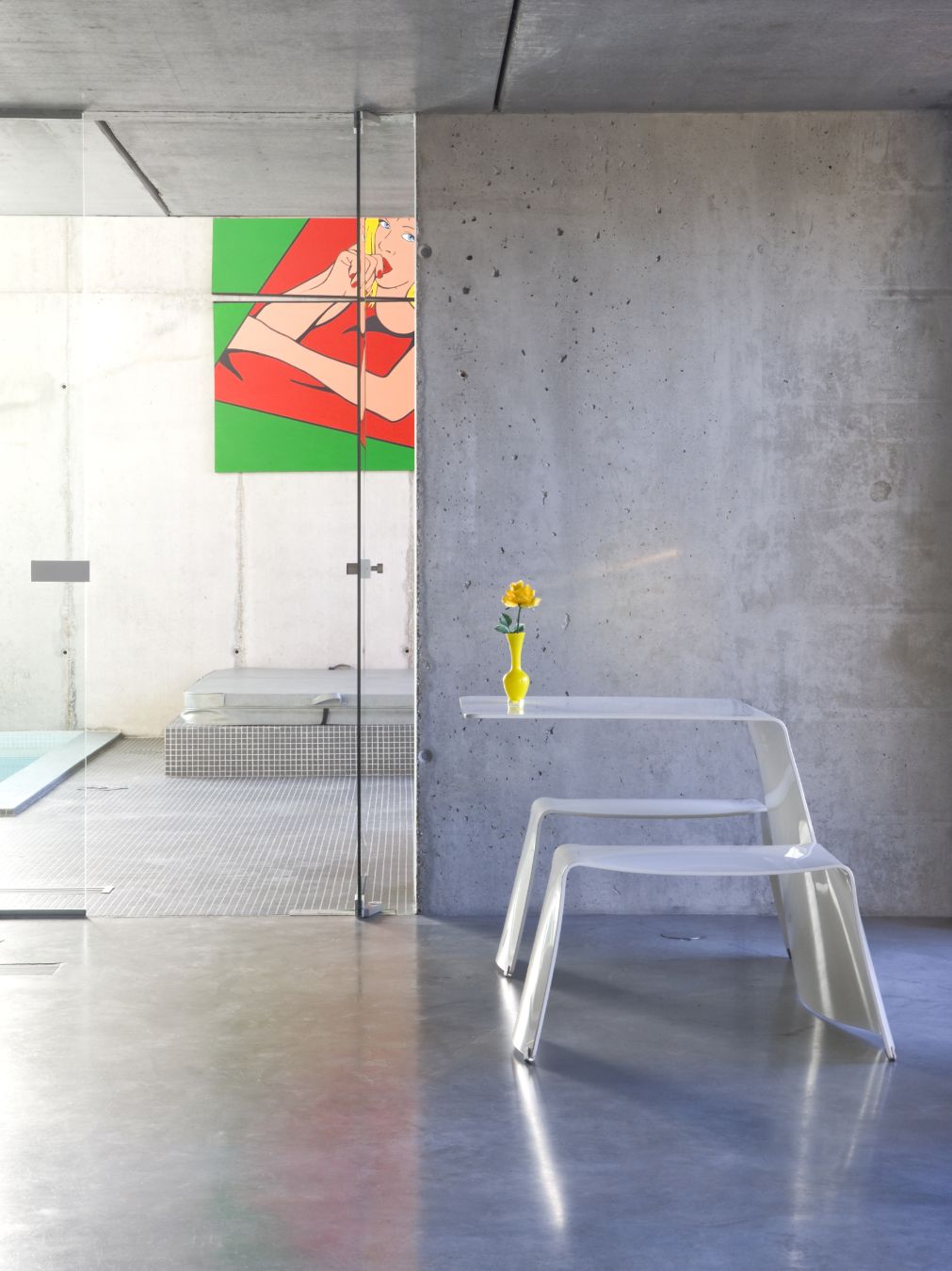 Extremis Picnik Tisch und Sitz Kombination im modernen Interieur mit Betonwand und Pool im Hintergrund.