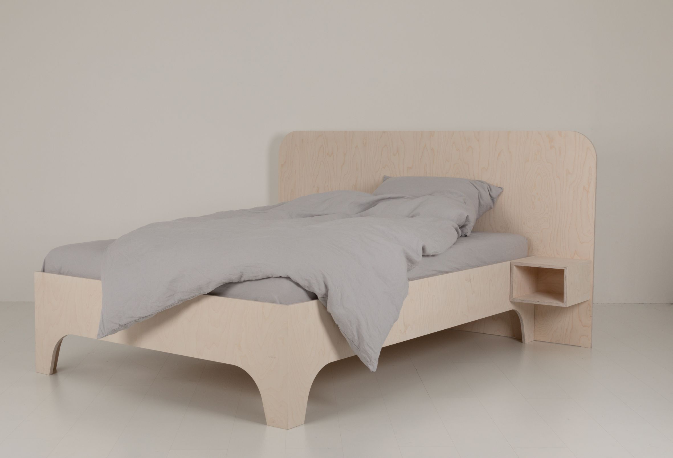 VALENTINA Bett 180x200 cm aus hellem Holz mit grauem Bettbezug und integriertem Nachttisch.