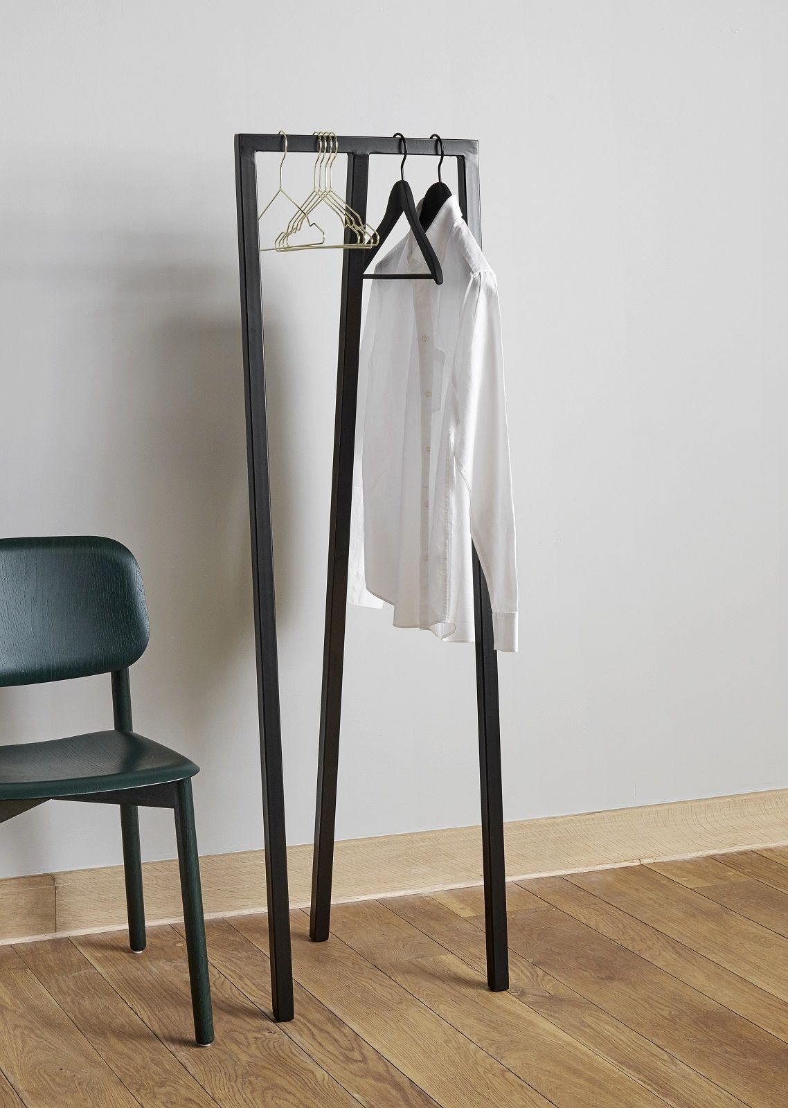 Hay Loop Stand Hall Garderobe in Schwarz mit Hemd und Kleiderbügeln, daneben ein grüner Stuhl.
