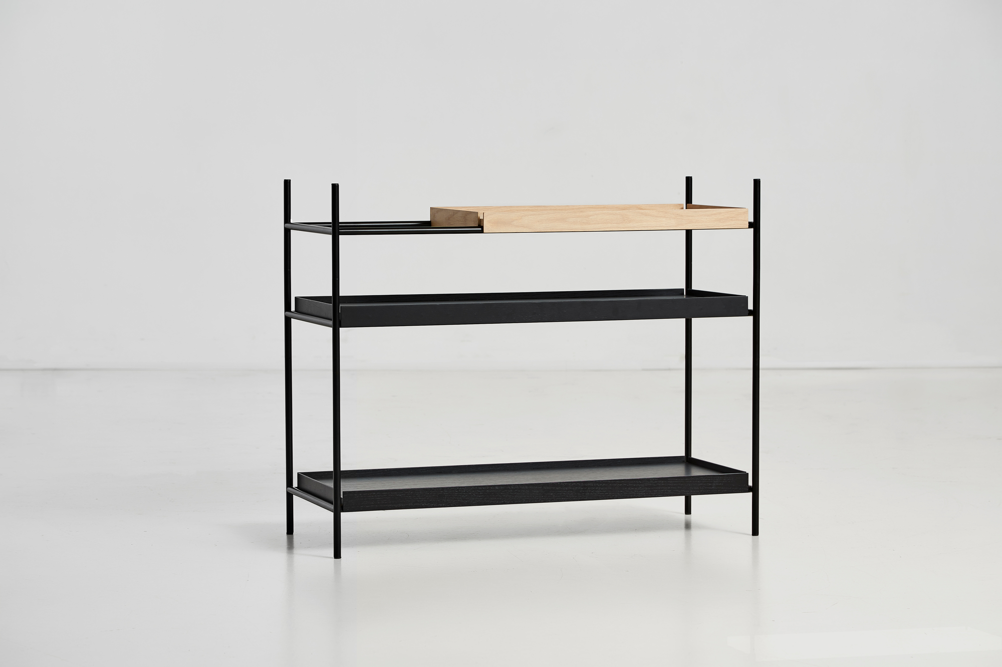 Tray Shelf Low Regal Woud: Modernes, niedriges Regal mit drei Ablagen in Schwarz und Naturholz.