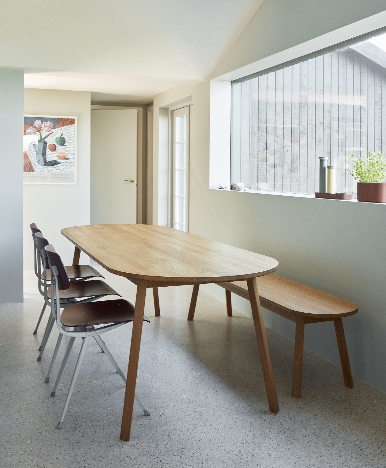 Heller Essbereich mit Triangle Leg Table Esstisch von Hay, Stühlen und Bank aus Holz.