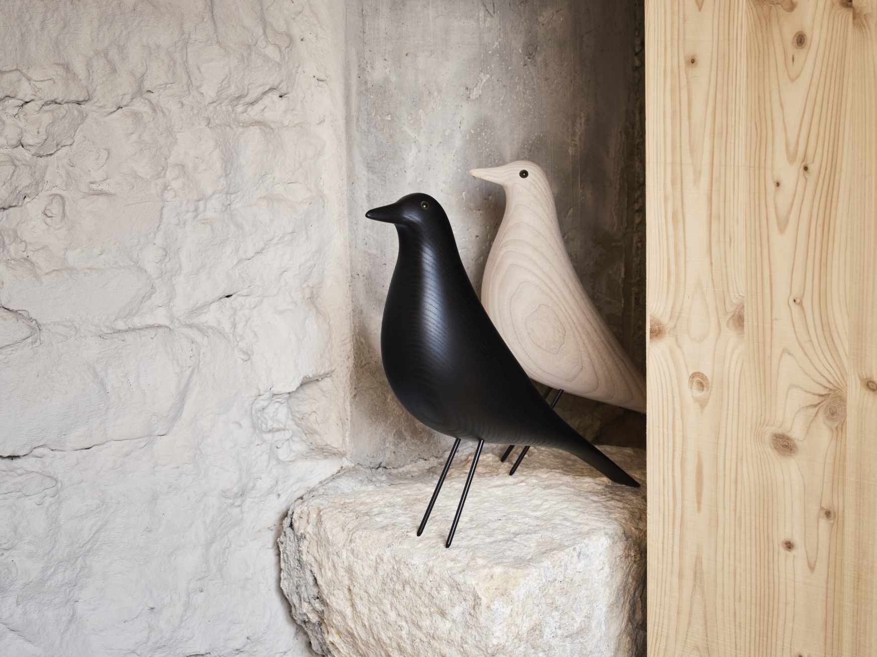 Eames House Bird Skulptur aus Esche, geölt, in Schwarz und Naturholz auf Steinsockel.
