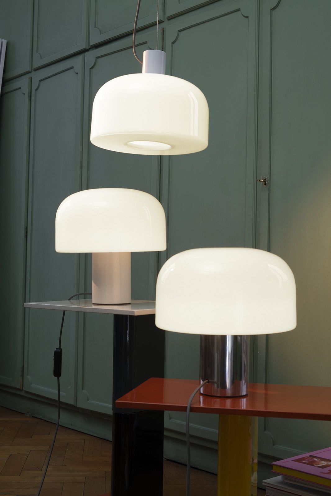 Drei moderne Bellhop Leuchten von Flos: eine Pendelleuchte, zwei Tischleuchten mit Glasdiffusor.