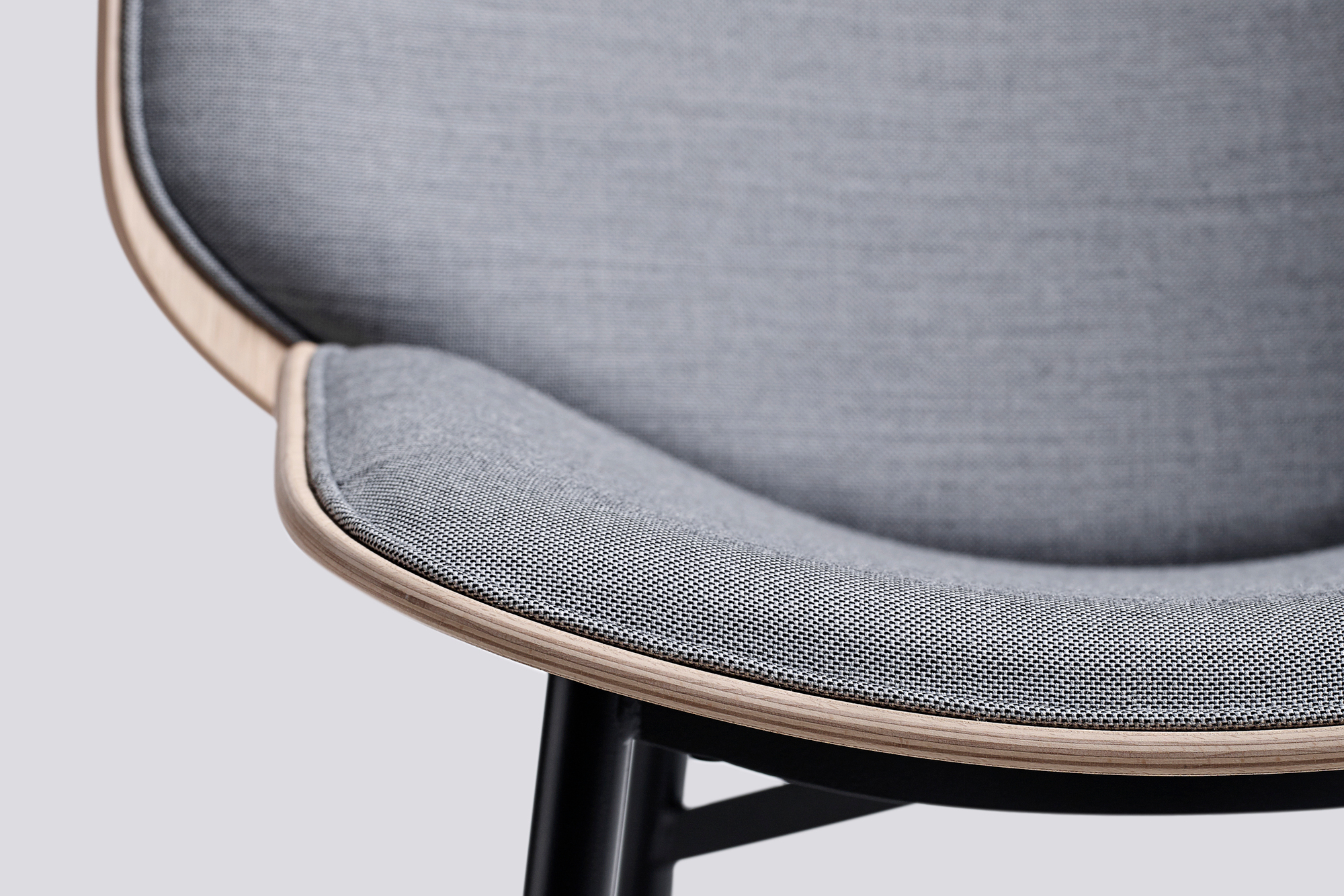 Detailaufnahme des Dapper Lounge Chair Sessels von Hay mit grauem Stoffbezug und Holzrahmen.
