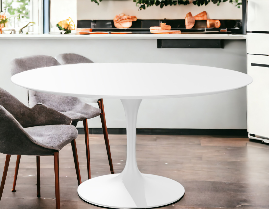 Weißer, runder Saarinen Esstisch mit Mittelfuß und grauen Stühlen im modernen Esszimmer.