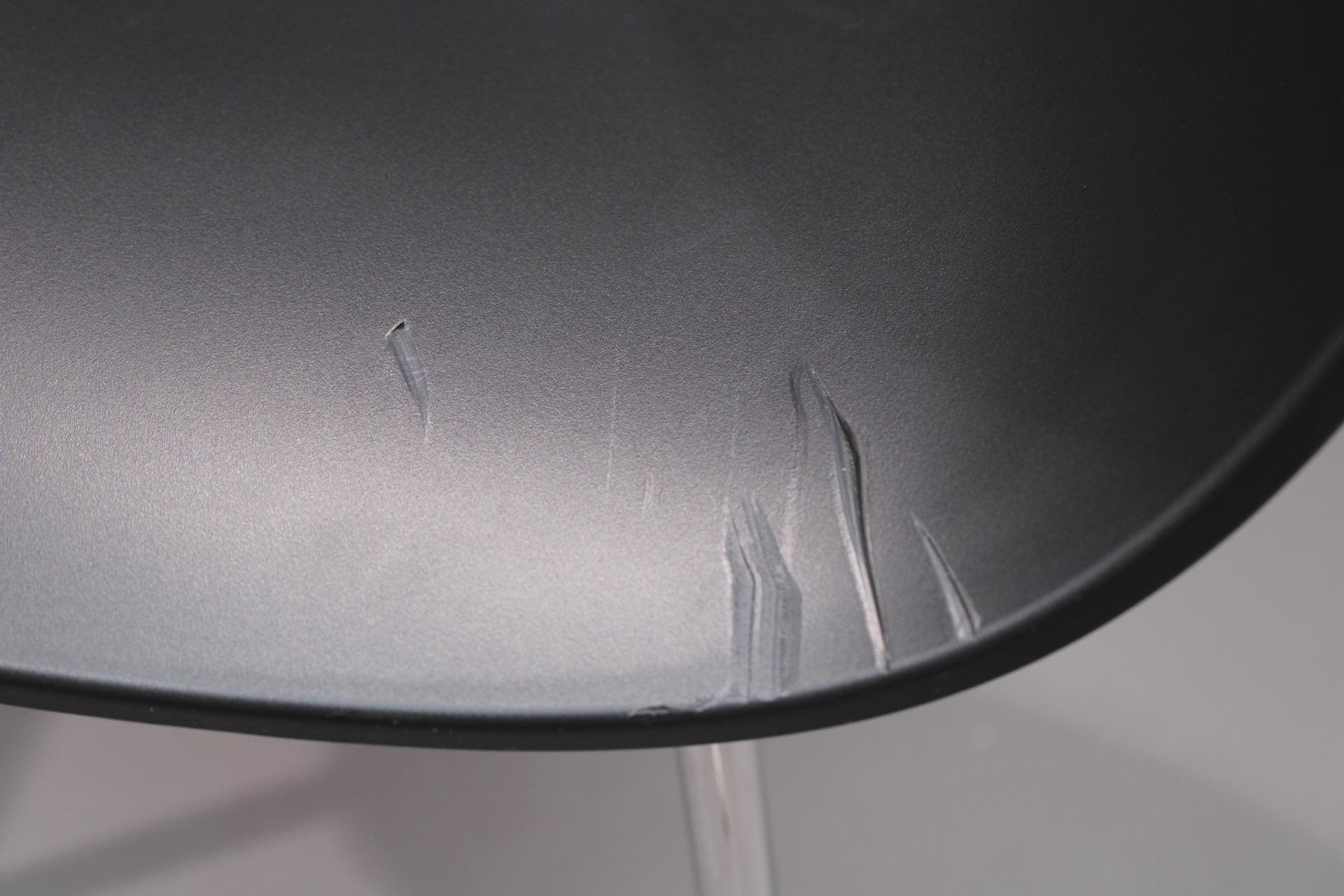 Detailaufnahme des schwarzen About A Chair (AAC 26) Stuhls mit Kratzern im Sitz. Mängelexemplar.