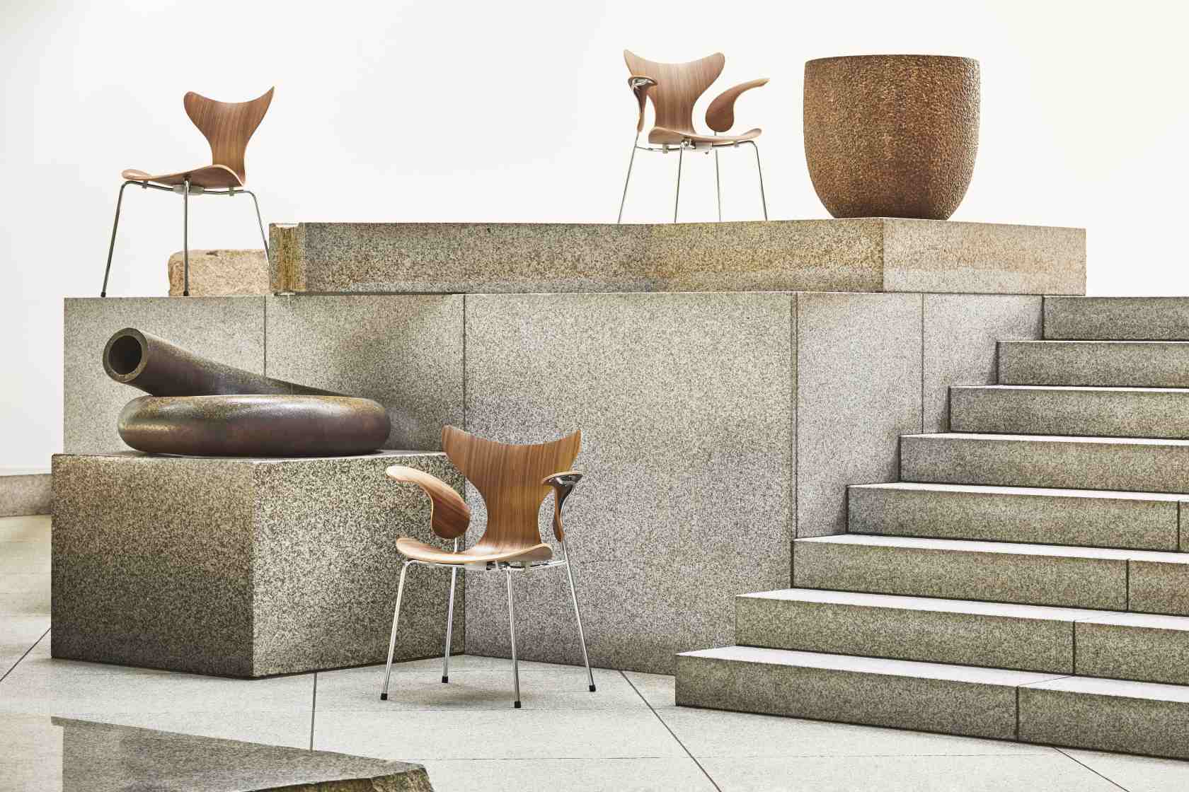 Fritz Hansen Lily Armlehnenstuhl 3208 aus Holz und Stahl auf Steinstufen, moderne Möbel.