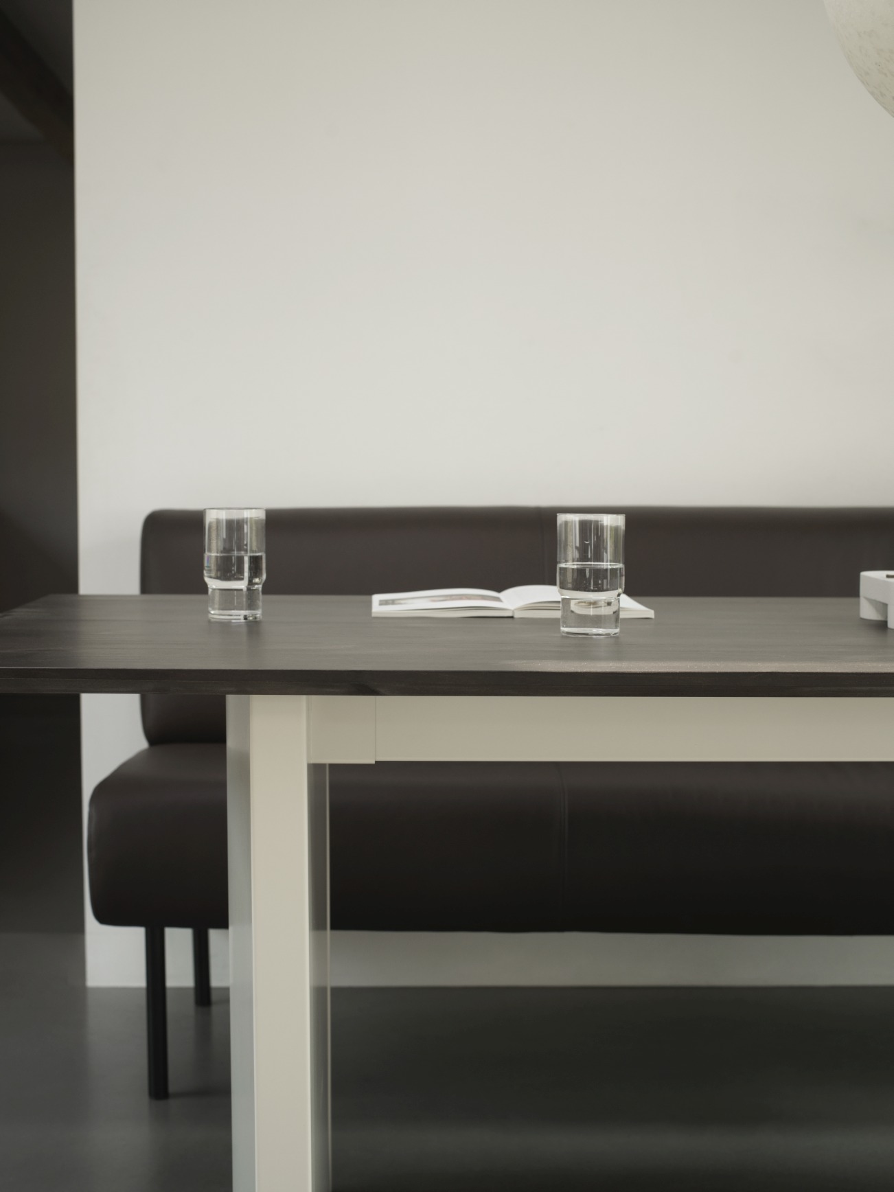 Normann Copenhagen Panel Tisch, Esstisch 200x90 cm mit Gläsern und Buch auf dunkler Tischplatte.