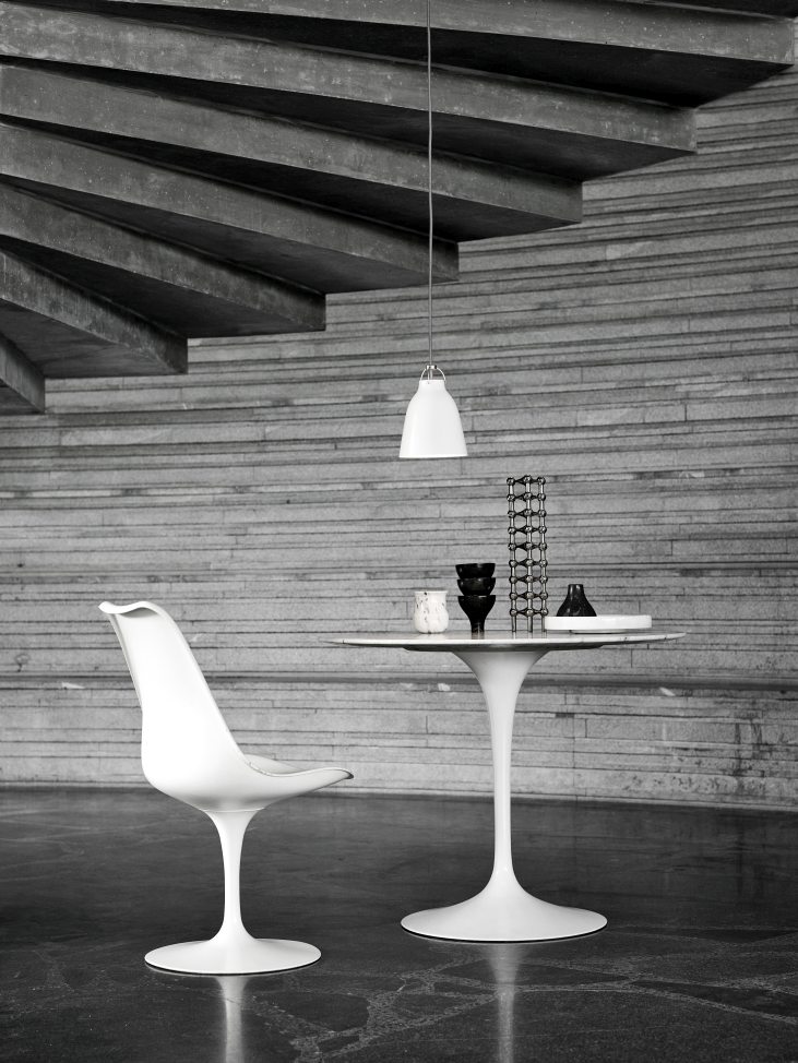 Weiße Caravaggio Pendelleuchte von Fritz Hansen über einem Esstisch mit Stuhl in modernem Interieur.