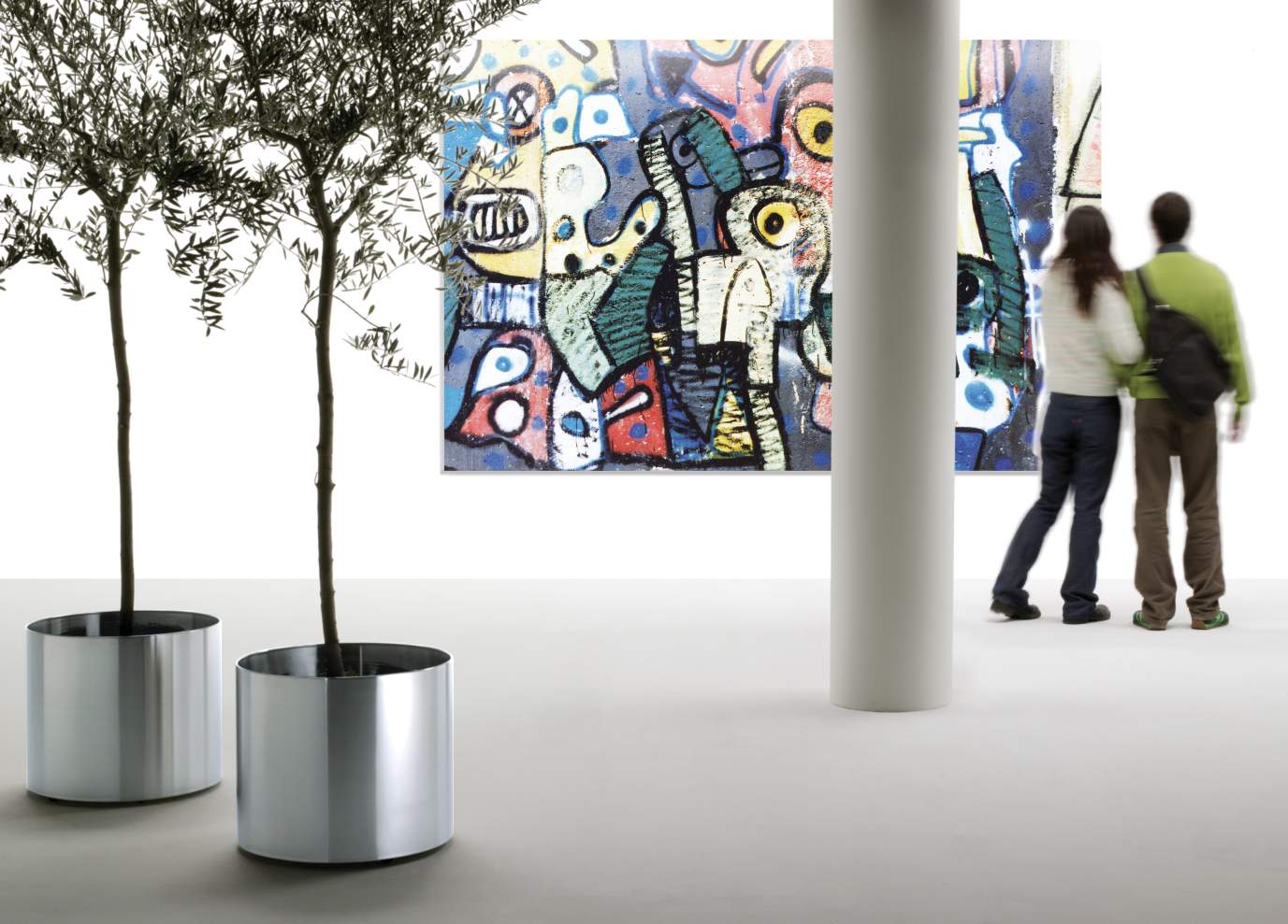 Zwei silberne Nox Flora Blumentöpfe von Rexite mit Olivenbäumen im modernen Ausstellungsraum, rollbare Pflanzgefäße.