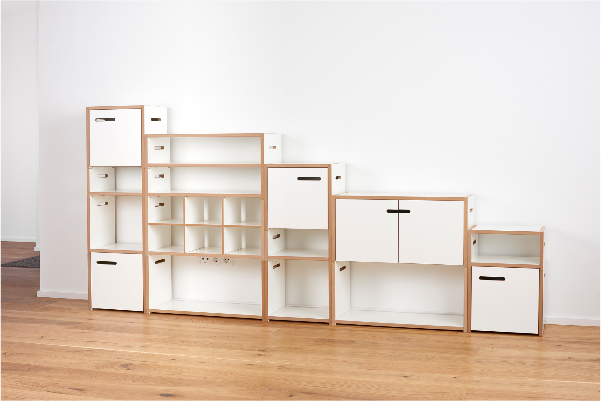 Tojo Hochstapler Regalsystem: Weißes, modulares Regal mit Fächern, Schubladen und Türen für flexible Stauraumlösungen.