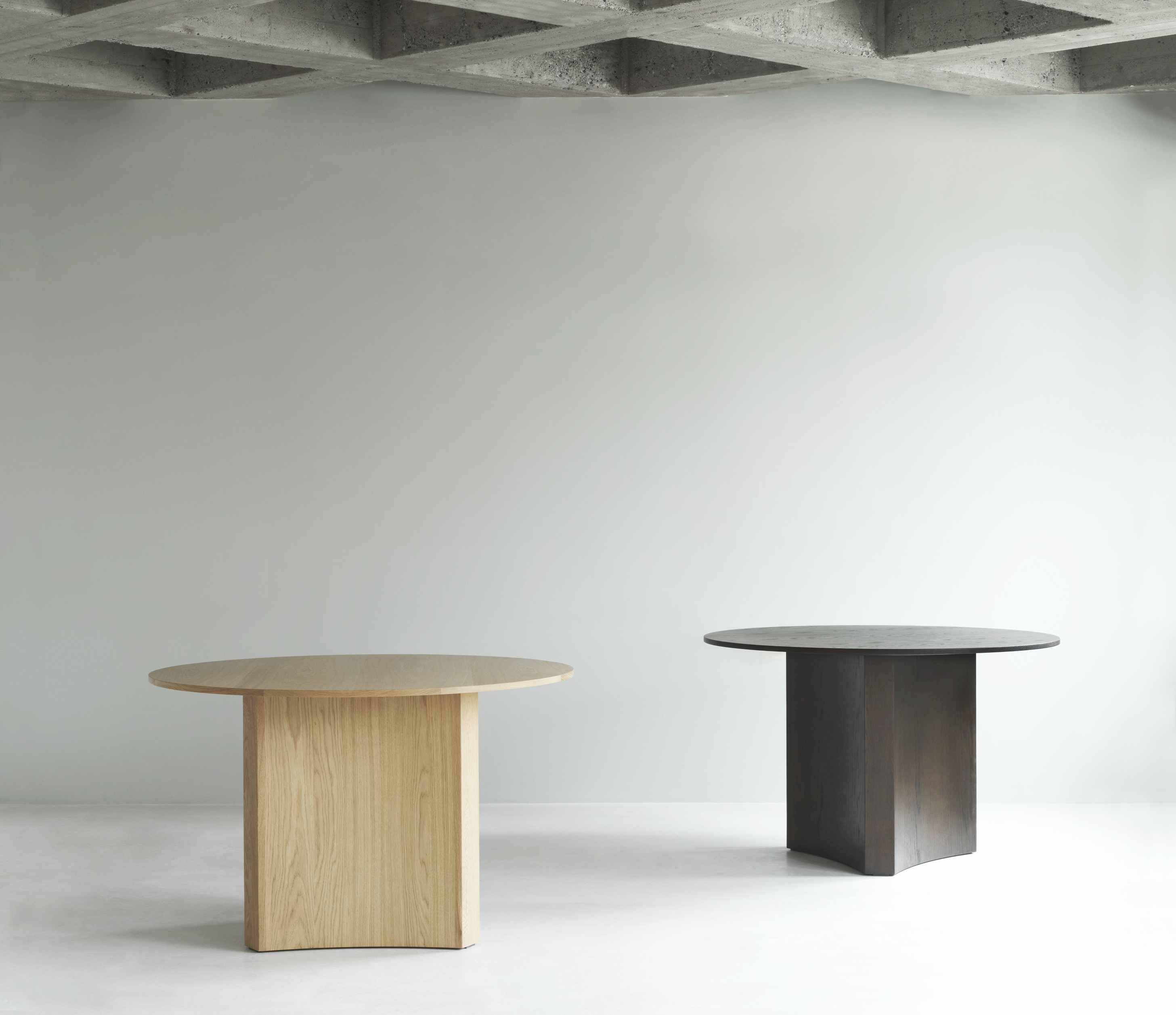Zwei Bue Table Esstische von Normann Copenhagen in hellem und dunklem Holz im minimalistischen Interieur.