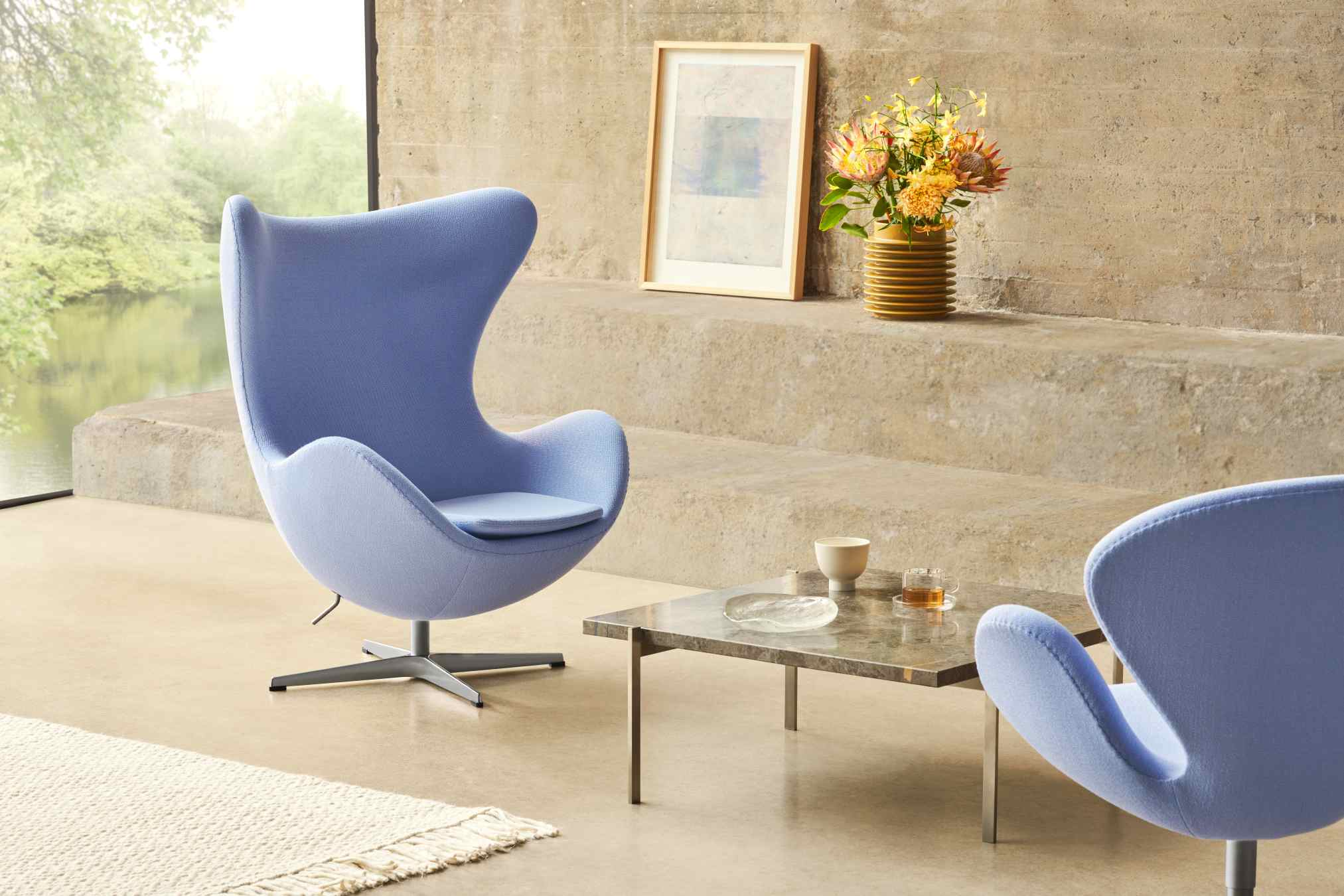 PK61 A Couchtisch von Fritz Hansen mit blauen Sesseln und Marmortisch in modernem Wohnzimmer.