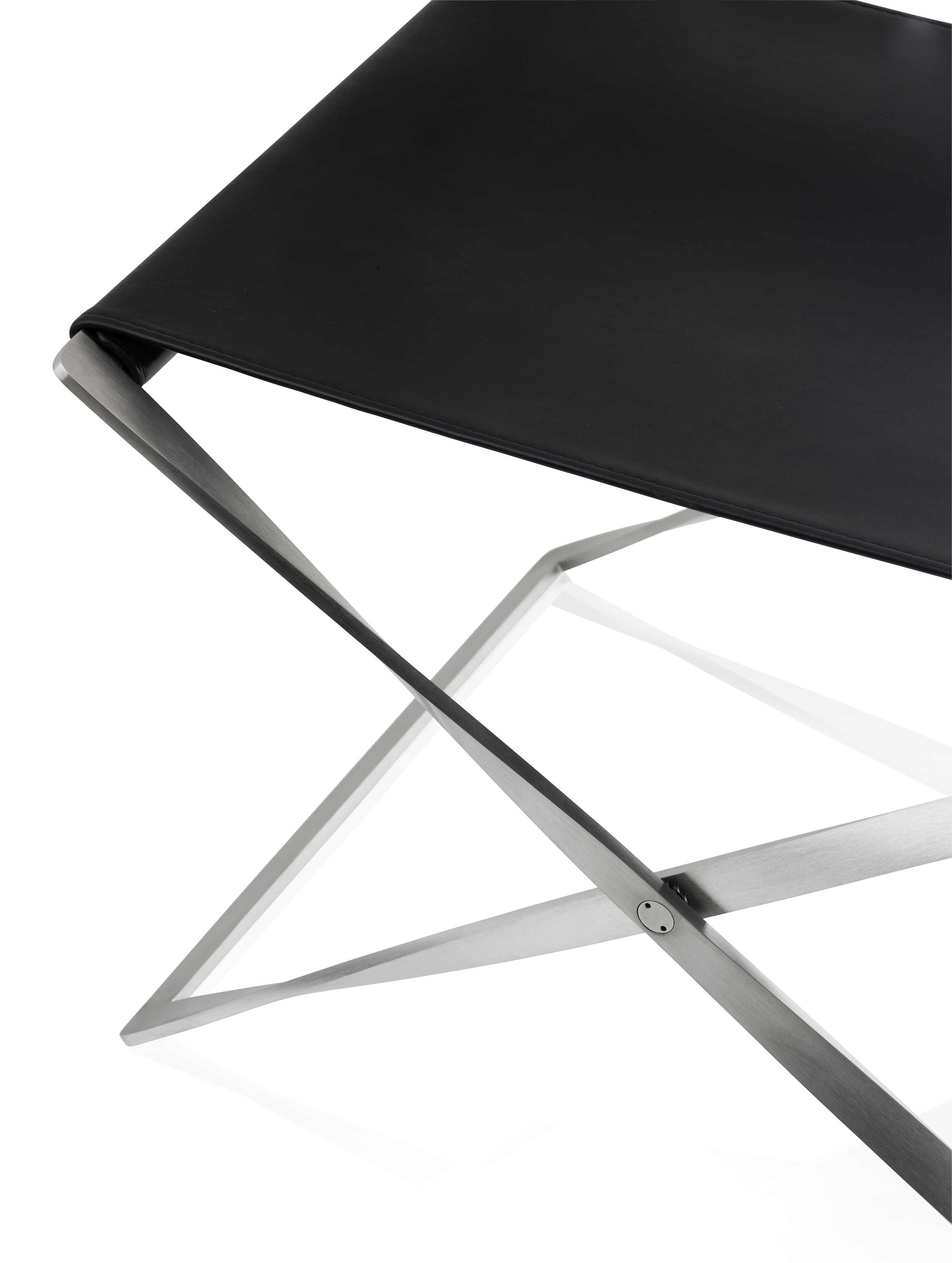 Detailaufnahme des PK91 Falthockers von Fritz Hansen mit schwarzem Leder und Stahlgestell.