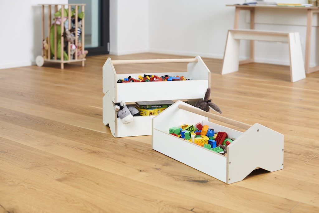 Tojo Kids Werkzeugkiste: Zwei weiße Spielzeugkisten aus Holz, gefüllt mit Spielzeug und Bauklötzen.