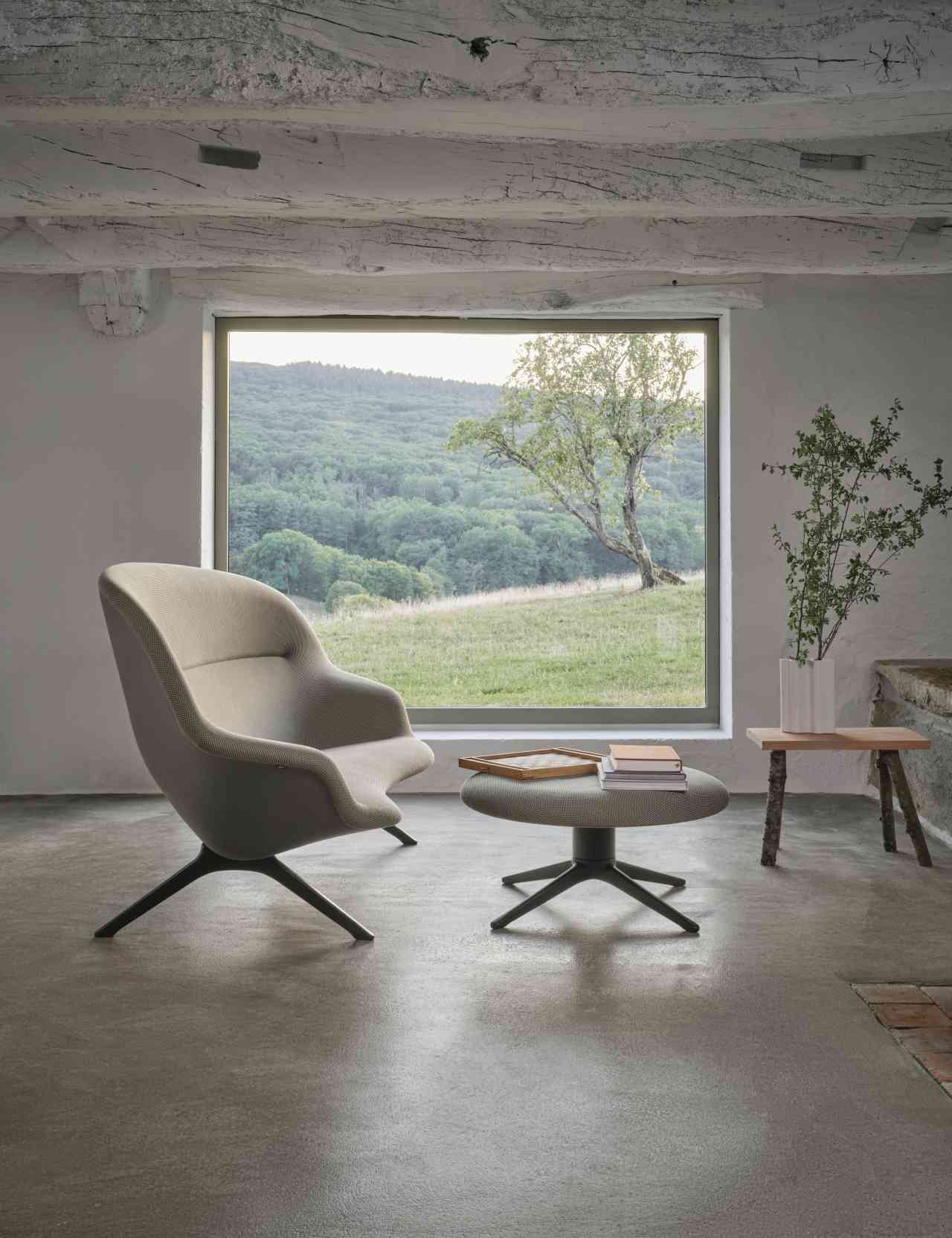 Beiger Abalon Sessel von Vitra mit Hocker und Blick auf grüne Landschaft.