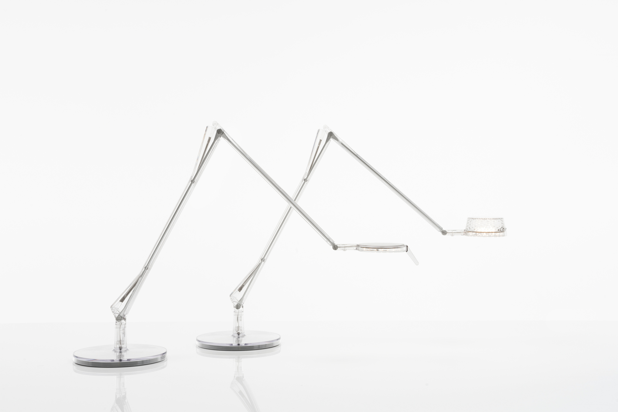 Zwei moderne Aledin Tischleuchten von Kartell mit filigranem Design und LED-Beleuchtung.