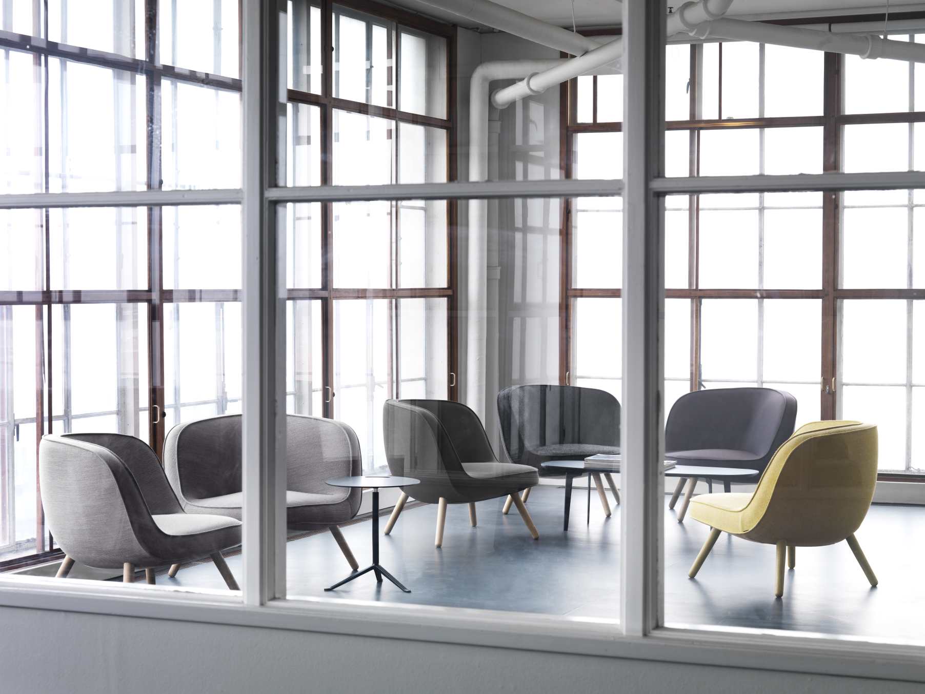 Via57 Sessel von Fritz Hansen in Grau- und Gelbtönen, arrangiert in einem hellen Raum.