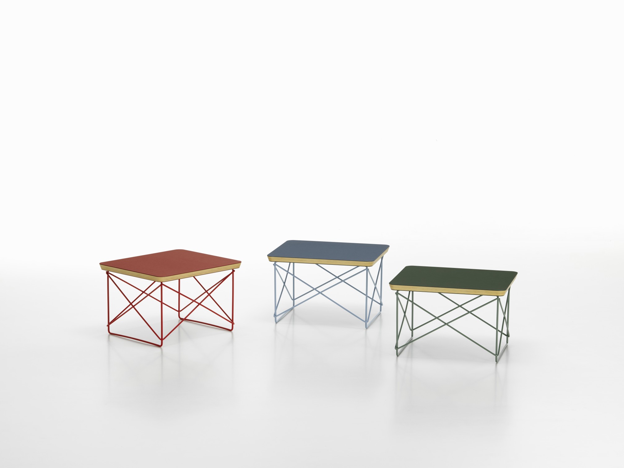 Drei Vitra LTR Beistelltische mit farbigem Linoleum und filigranem Stahlgestell in Rot, Blau und Grün.