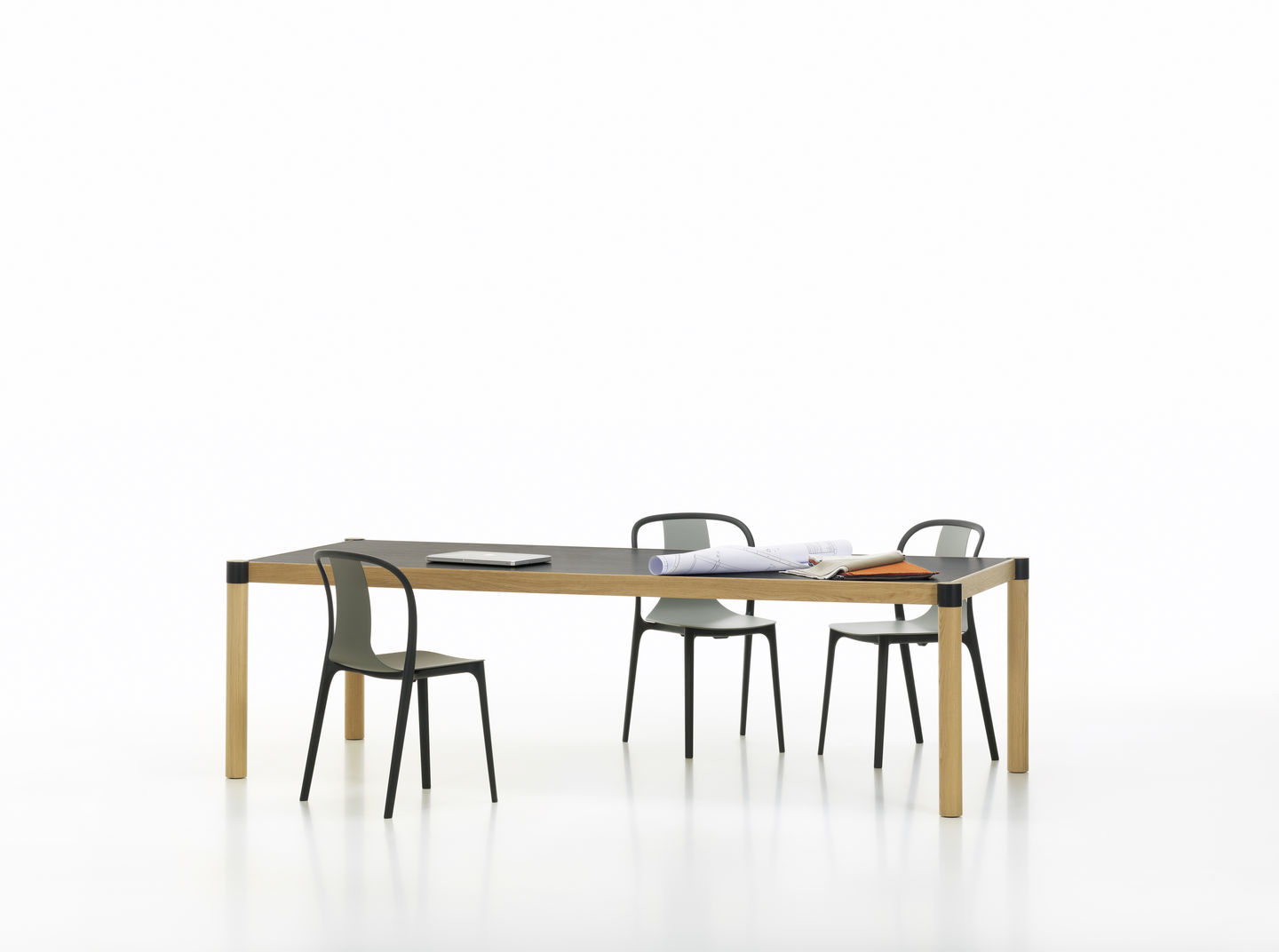 Belleville Armchair Wood Stuhl von Vitra an einem Tisch mit Laptop und Bauplänen.