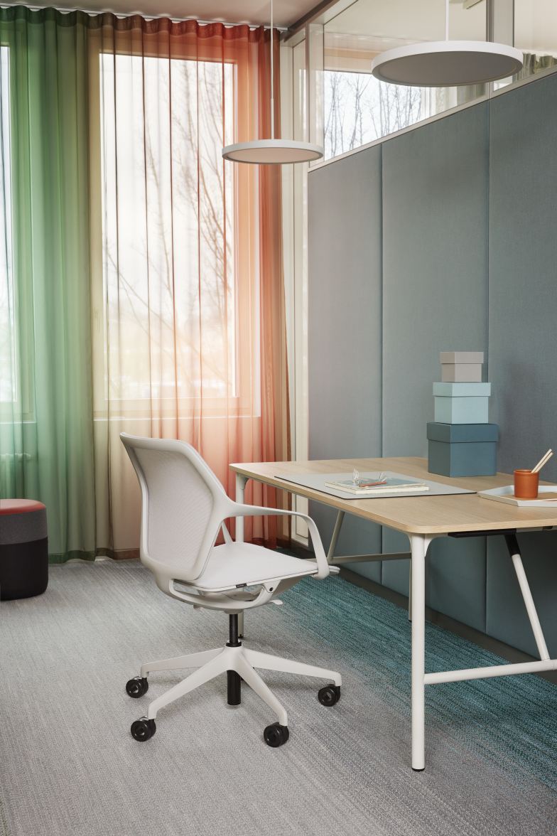 Ray Work Bürodrehstuhl von Brunner in Weiß vor einem modernen Schreibtisch und farbigen Vorhängen.