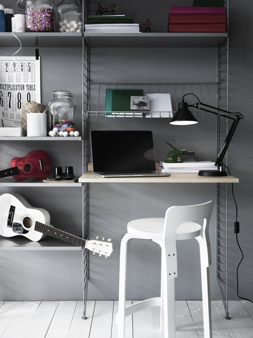 Arbeitsplatz mit String Furniture Regalsystem, Schreibtisch, Laptop, Lampe und Gitarren. Homeoffice Einrichtung.
