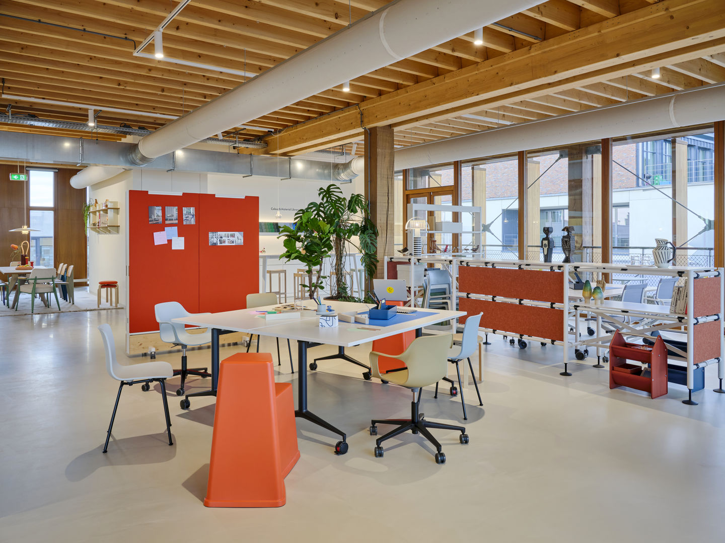 Heller Büroraum mit Vitra MedaMorph Klapptisch, Bürostühlen und modularen Regalen für flexible Arbeitsbereiche.