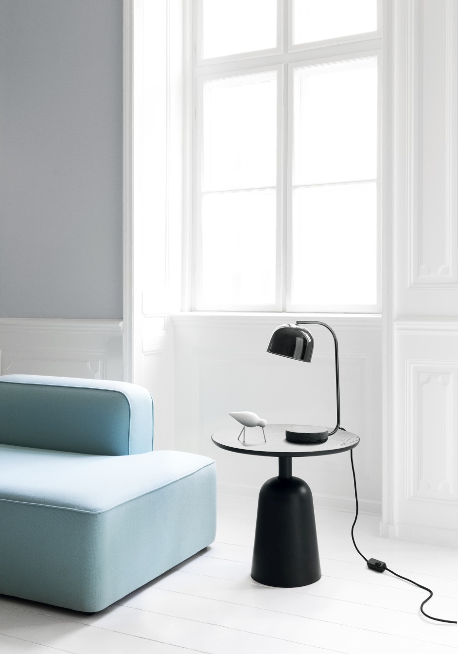 Schwarzer Normann Copenhagen Turn Table Tisch mit Lampe und Dekofigur in modernem Wohnzimmer.
