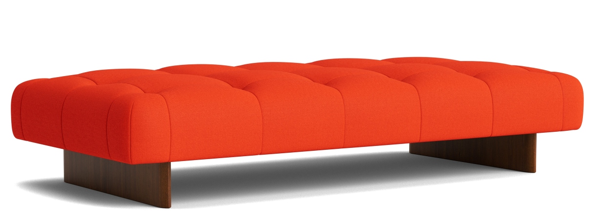 Orangefarbene Hay Quilton Daybed Liege mit Knopfheftung und dunklem Holzsockel auf weißem Hintergrund.