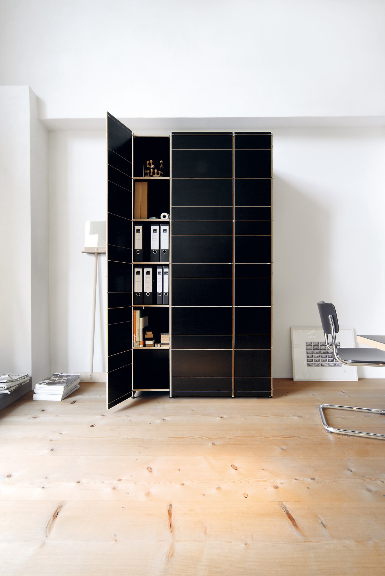 K1 Armoire von Nils Holger Moormann, schwarzer Holzschrank mit offenen Fächern und Büromaterial im minimalistischen Design.