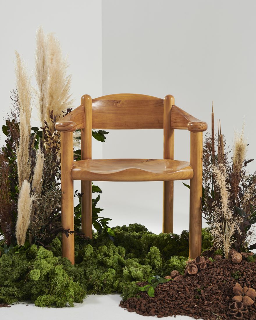 Gubi Daumiller Stuhl aus Holz, skandinavisches Design, umgeben von Moos und Pflanzen für natürliche Atmosphäre.