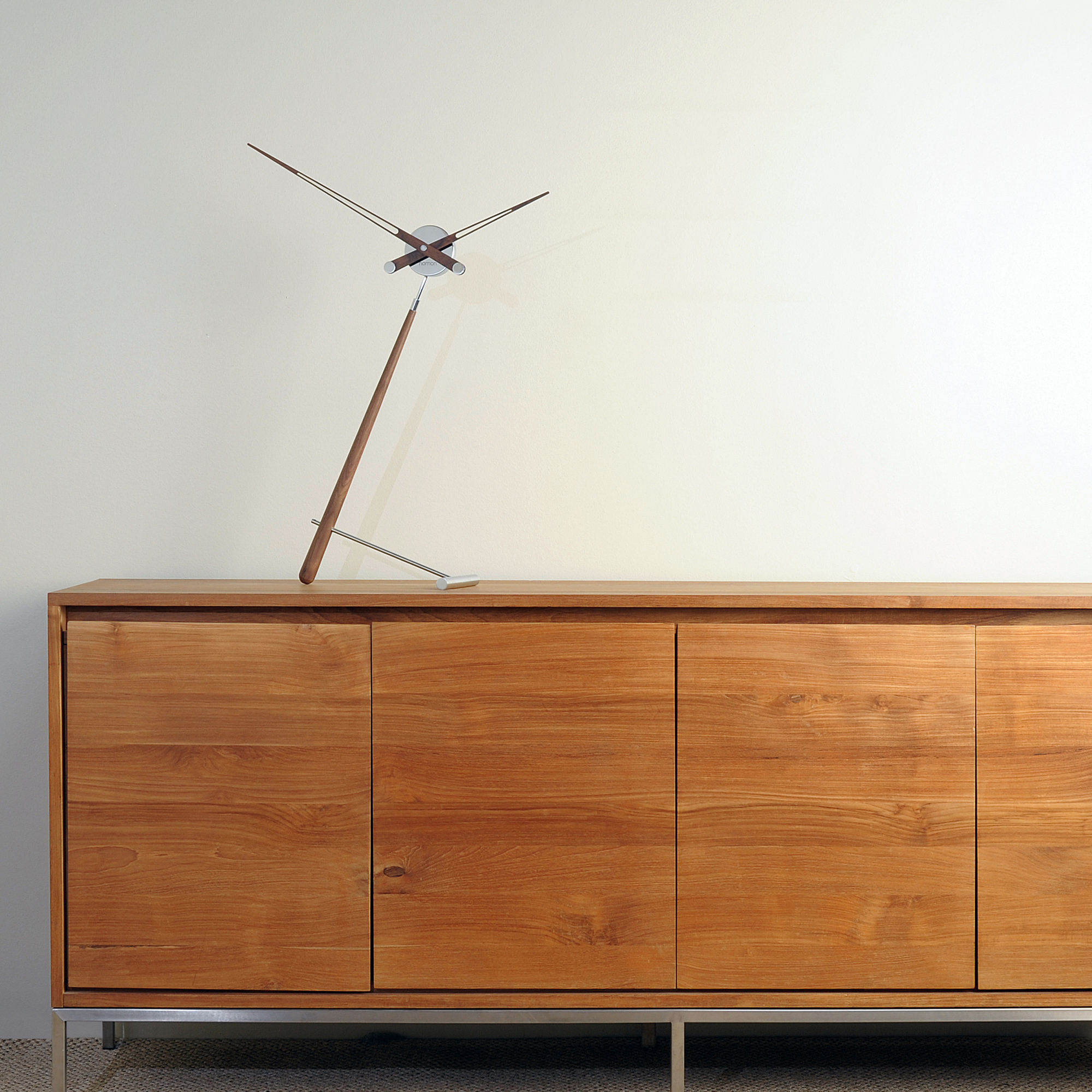 Nomons Puntero Tischuhr aus Holz und Metall auf einem Sideboard. Design Tischuhr.