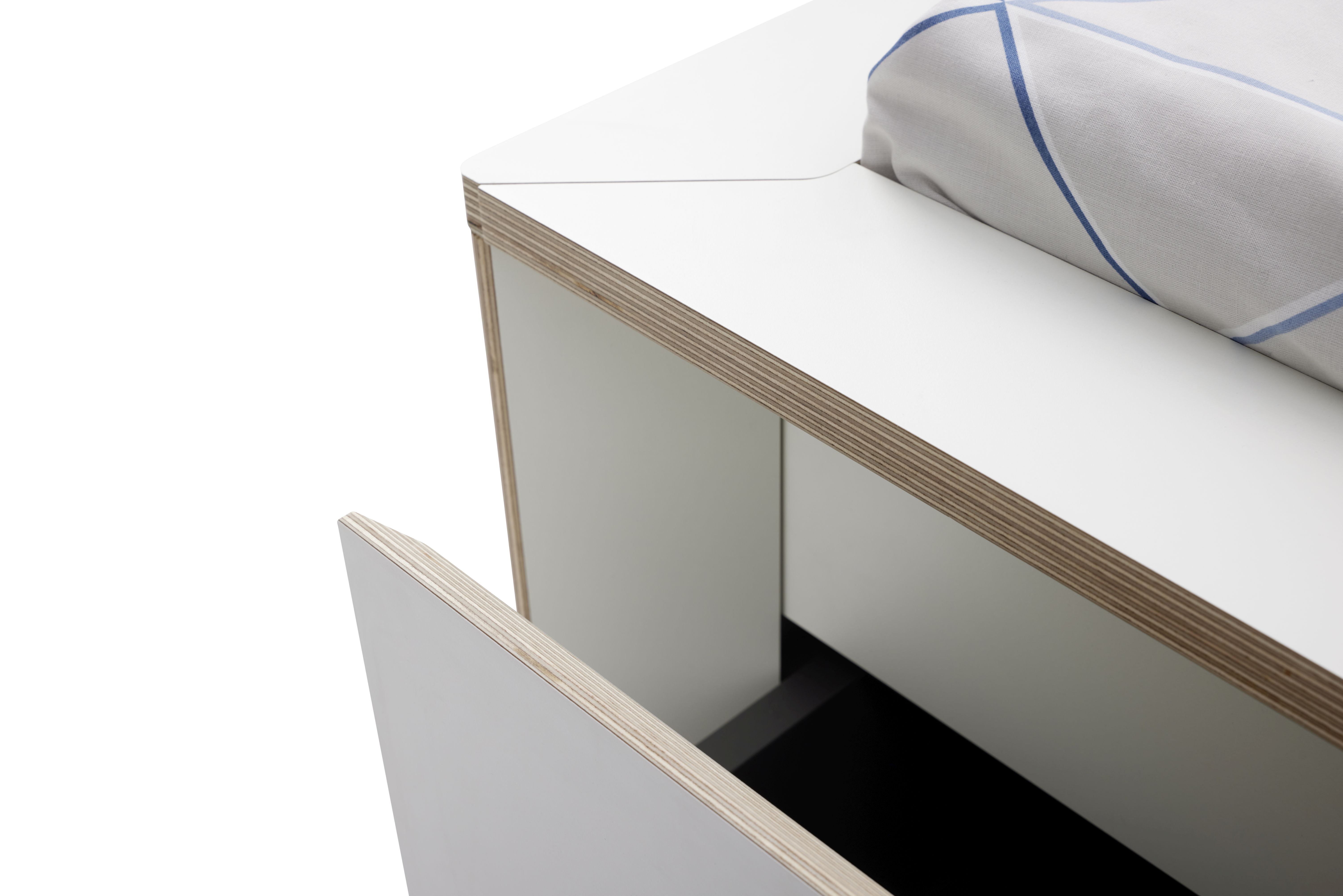 Detailaufnahme vom Spaze Bett von Müller Möbelwerkstätten mit offenem Schubfach und Bettwäsche.