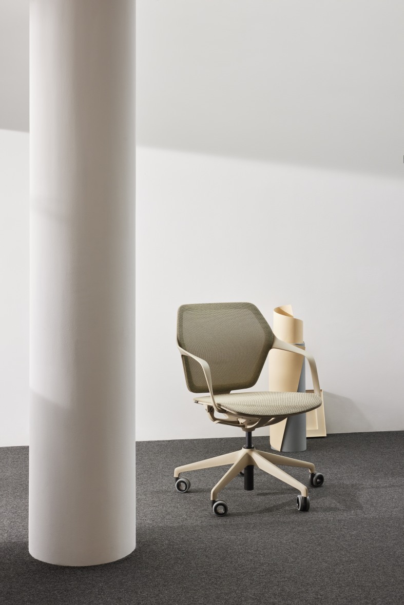 Ray Work Bürodrehstuhl von Brunner mit Armlehnen und Rollen vor einer weißen Wand und Säule.