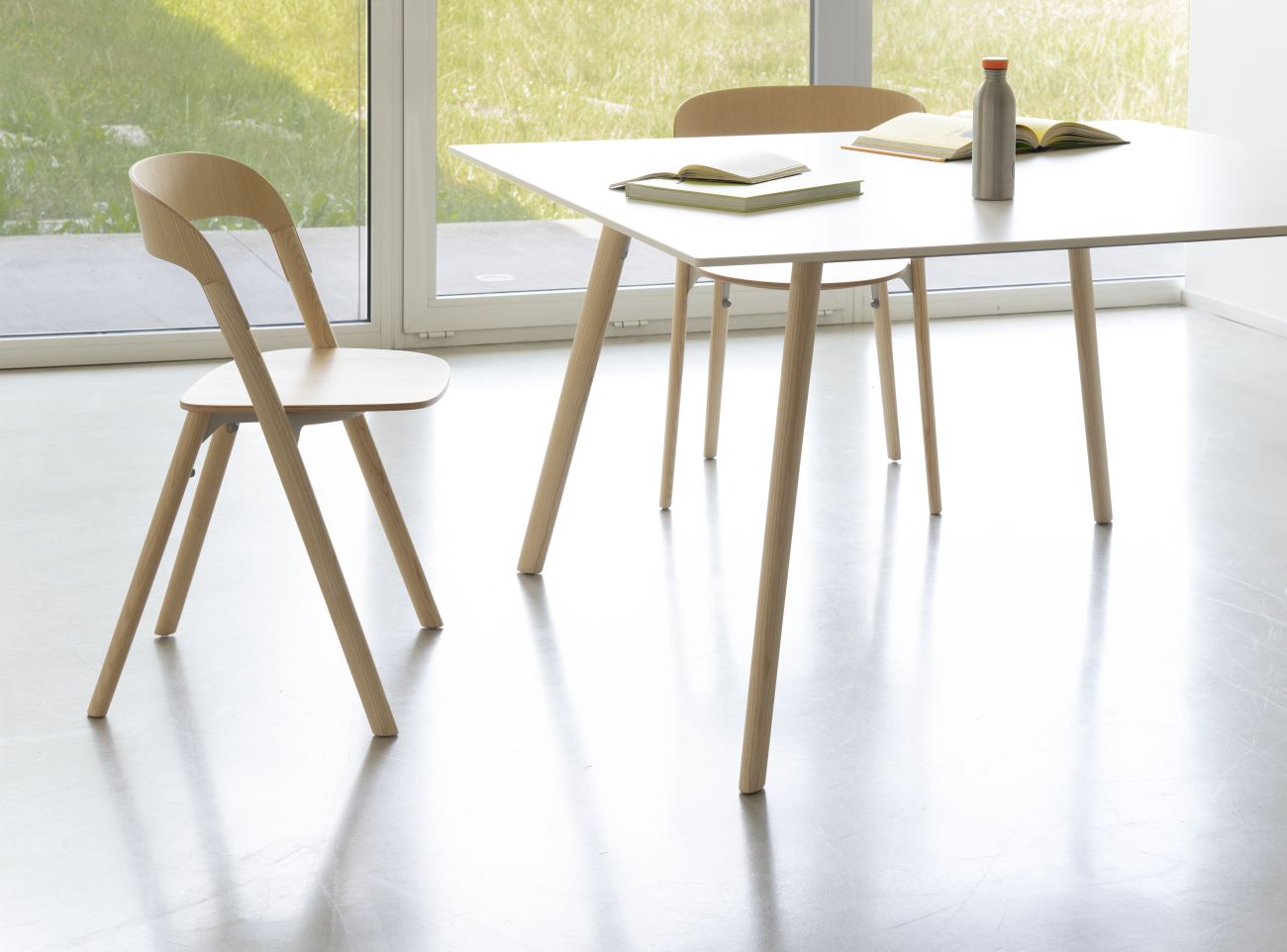 Heller Essbereich mit Magis Pilo Tisch, Holzstuhl und minimalistischer Dekoration für ein modernes Zuhause.