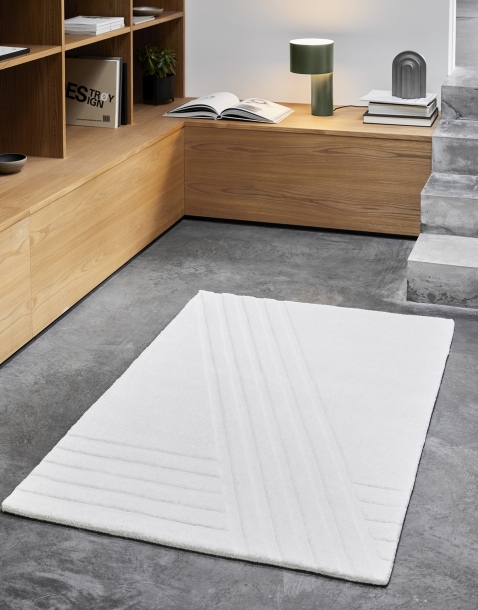 Weißer Kyoto Teppich von Woud, 90x140 cm, mit geometrischem Muster auf grauem Boden.