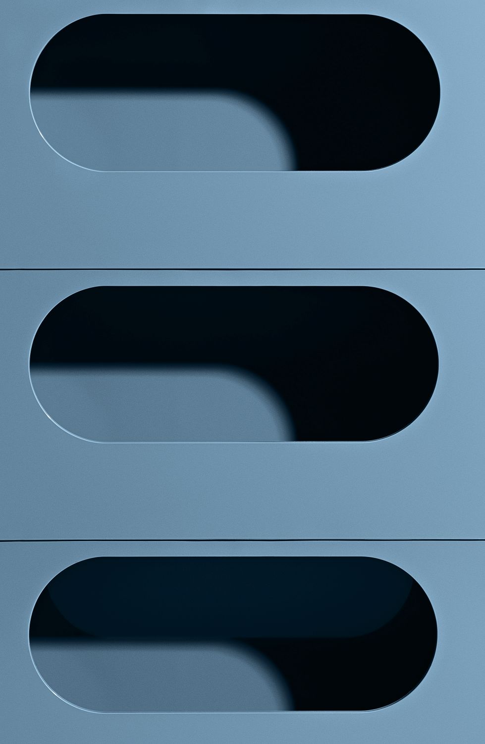 Detailaufnahme des blauen Boby Rollcontainers B32 mit drei Schubladen und ovalen Griffen.