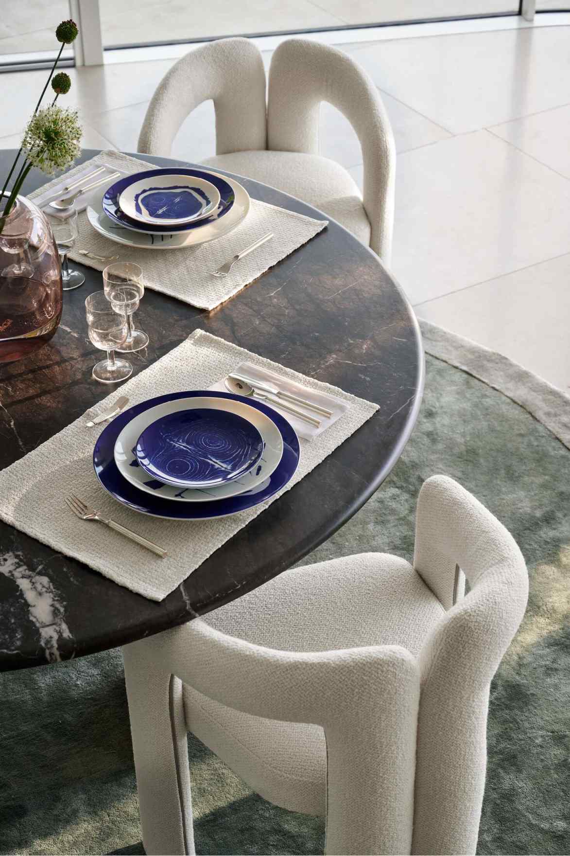 Esstisch mit Gedeck und zwei weißen 562 Dudet Sesseln von Cassina im modernen Interieur.