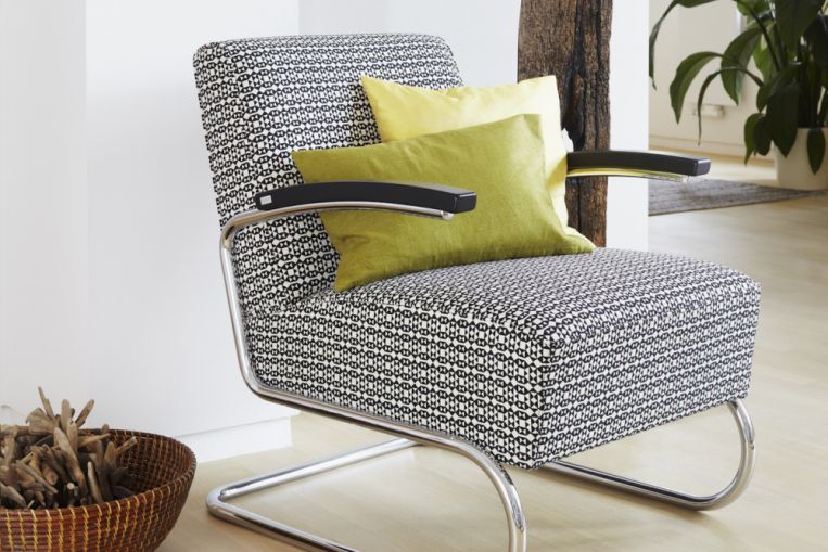 S 411 Thonet Freischwinger Sessel mit schwarz-weiß gemustertem Bezug und Kissen in Gelb- und Grüntönen.