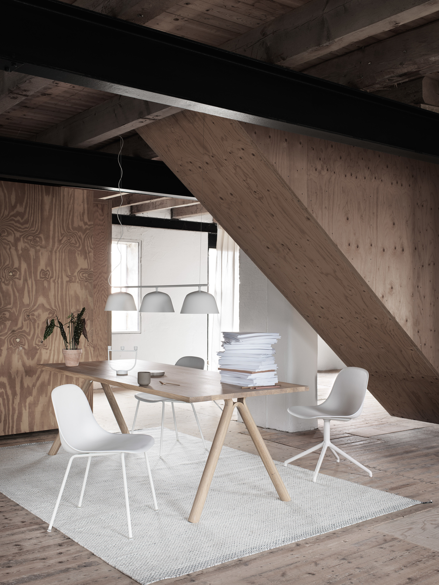 Heller Raum mit Esstisch und weißen Fiber Side Chairs von Muuto mit Stahlrohrgestell.