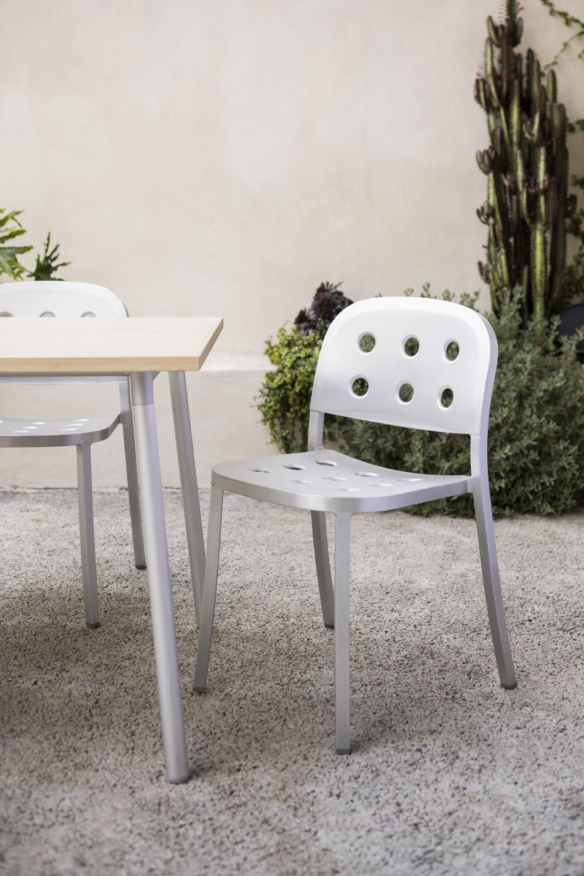 Emeco 1 Inch Aluminium Stacking Chair: Silberner Design Stuhl mit Löchern im Garten.