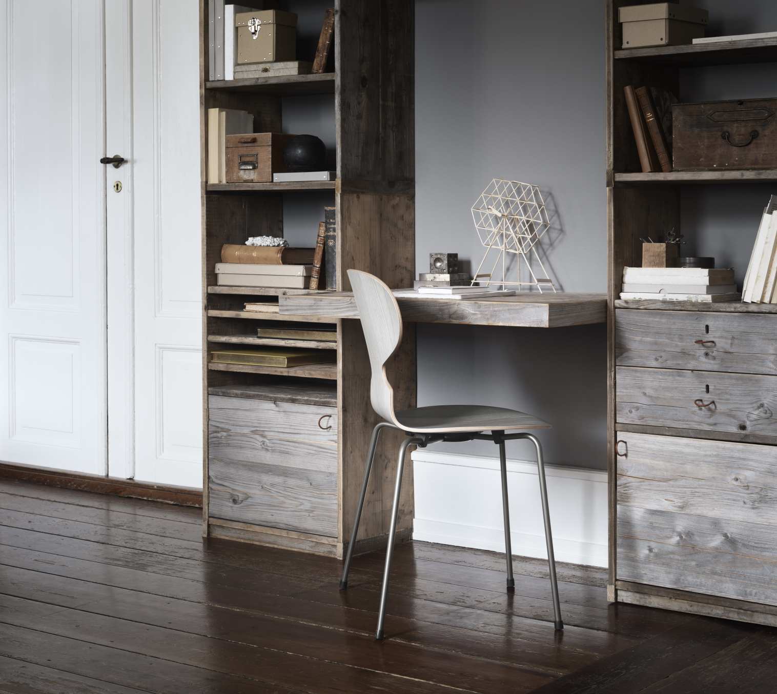 Die Ameise Stuhl von Fritz Hansen mit vierbeinigen Stahlgestell am Schreibtisch im rustikalen Arbeitszimmer.