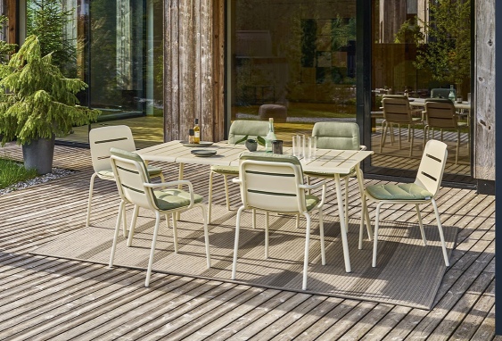 Vapio Sessel und Gartentisch von Weishäupl auf einer Terrasse, Outdoor Möbel mit grünen Sitzkissen.
