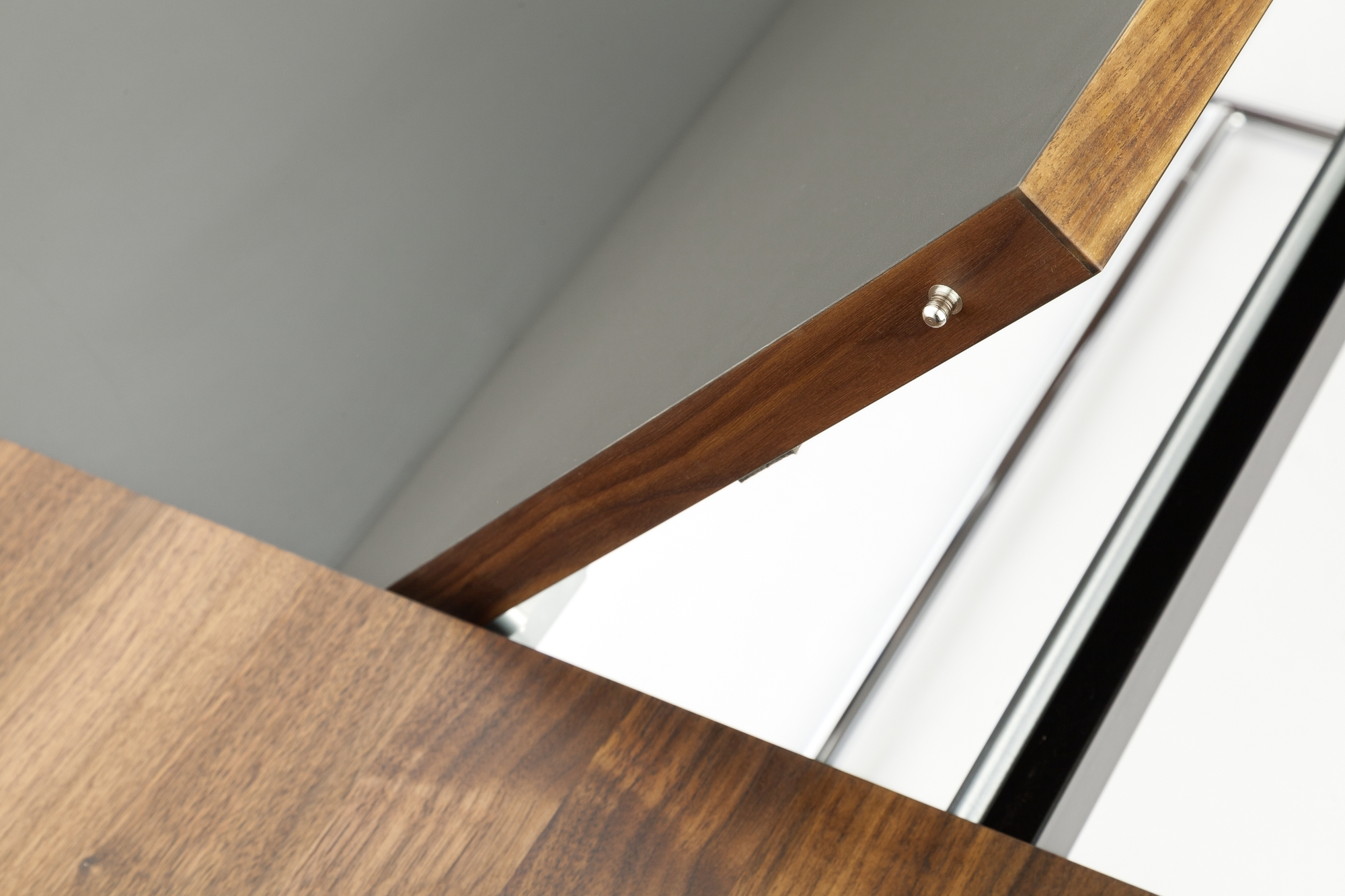 Detailaufnahme des Thonet S 1072 Esstisches mit Ausziehfunktion, Holzrahmen, grauer Tischplatte und verchromtem Gestell.