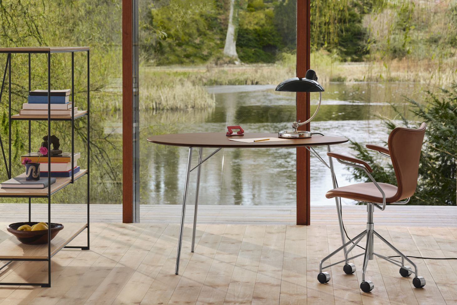 Fritz Hansen Egg Table Tisch mit Bürostuhl und Regalsystem vor Fenster mit Seeblick.