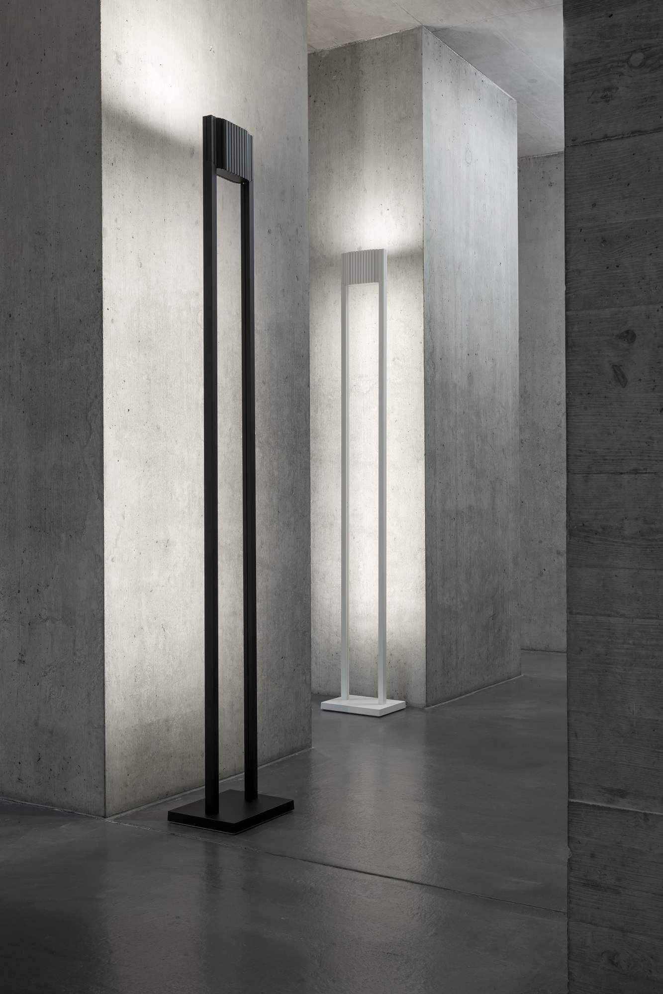 Unic LED Stehleuchte in Schwarz und Weiß vor Betonwand, moderne Innenbeleuchtung.