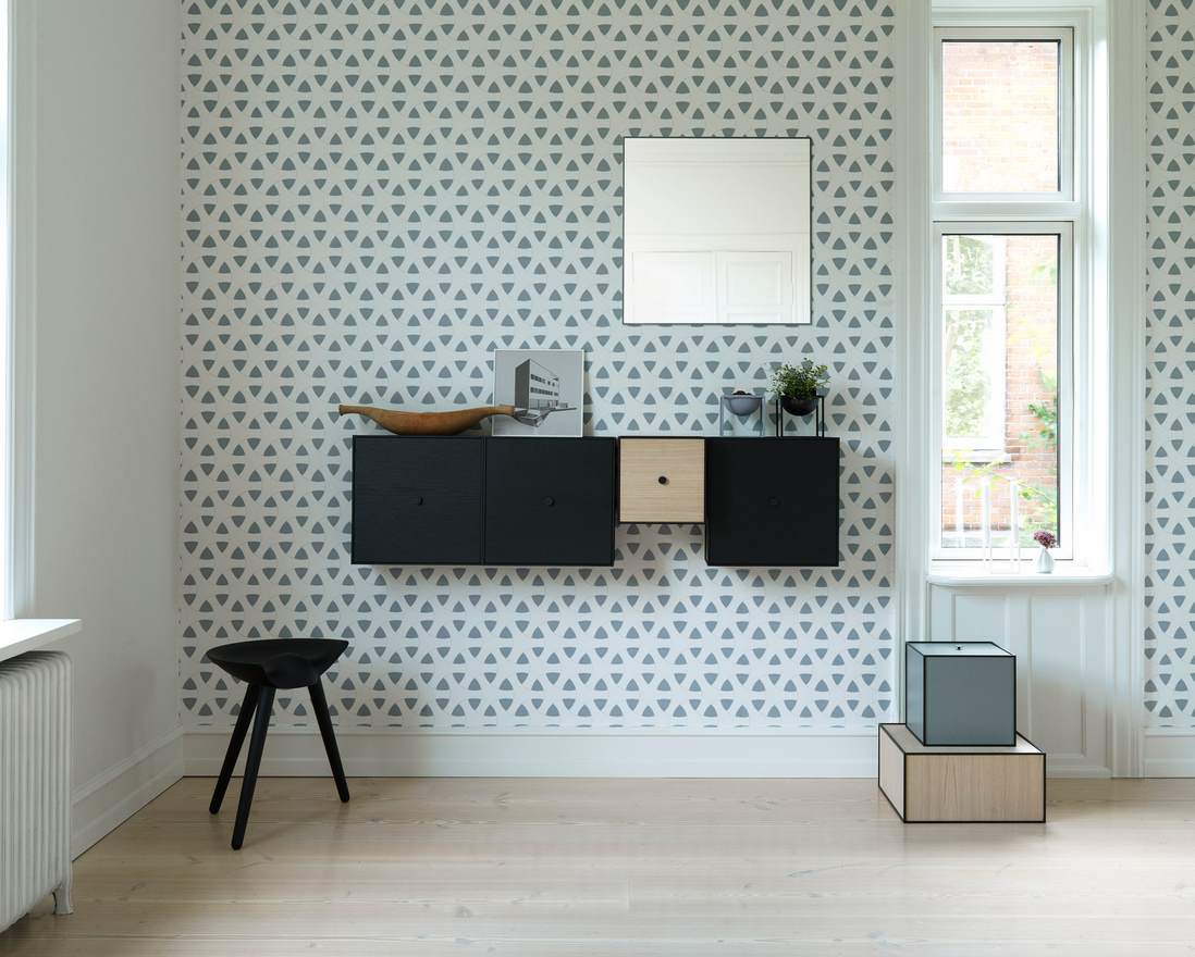 Schwarzer ML42 Hocker von Audo im modernen Wohnzimmer mit Wandmontage-Schränken und minimalistischem Design.